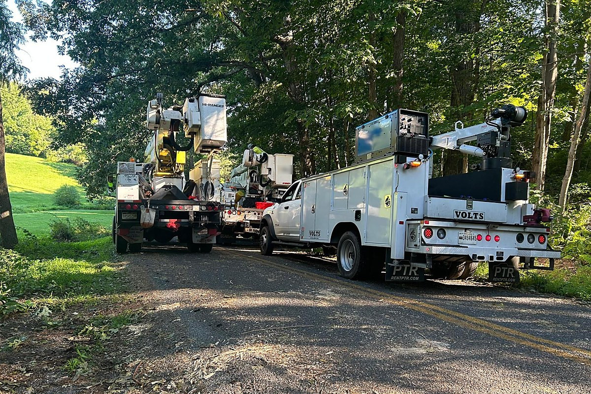 VOLTS service truck on a wooded road with boom units